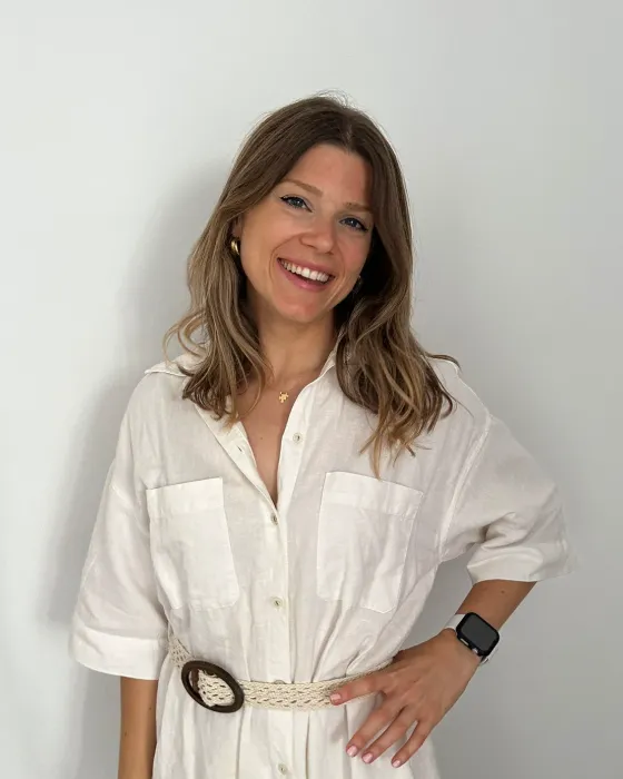 Laura Margarit, logopeda infantil, sonriendo frente a una pared blanca
